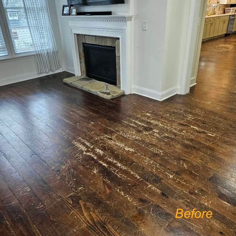 Dark hardwood near fireplace — heavily scratched before refinishing